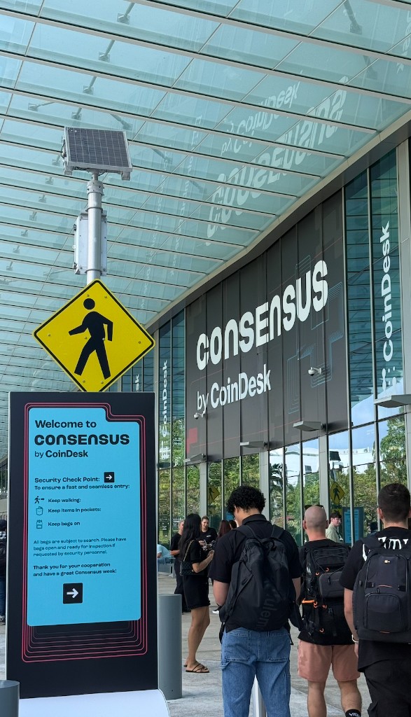 Consensus by CoinDesk entrance at the Miami Beach Convention Center — security checkpoint signage and attendees