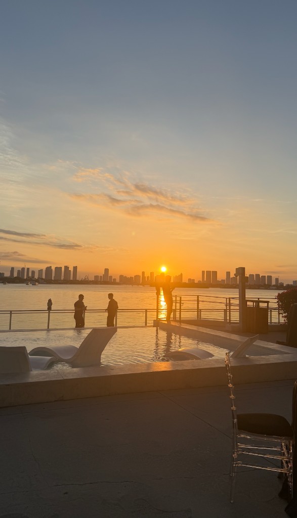 Miami skyline and bay at golden hour from a rooftop terrace during conference week